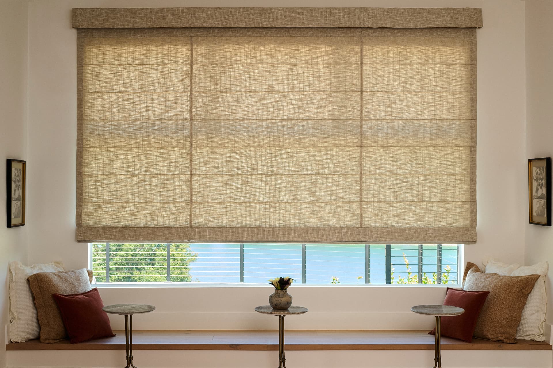 Woven-wood Roman shade with matching valance above a window bench